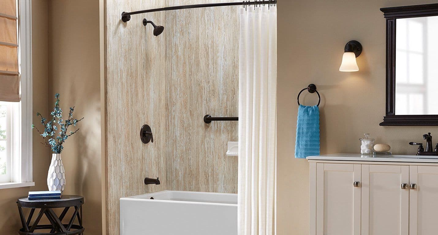 A combination shower tub with beige textured walls and black fixtures, including a grab bar.