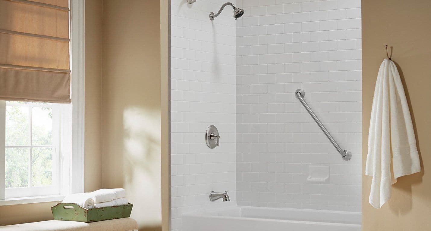 A combination shower tub with white seaside subway tile walls.